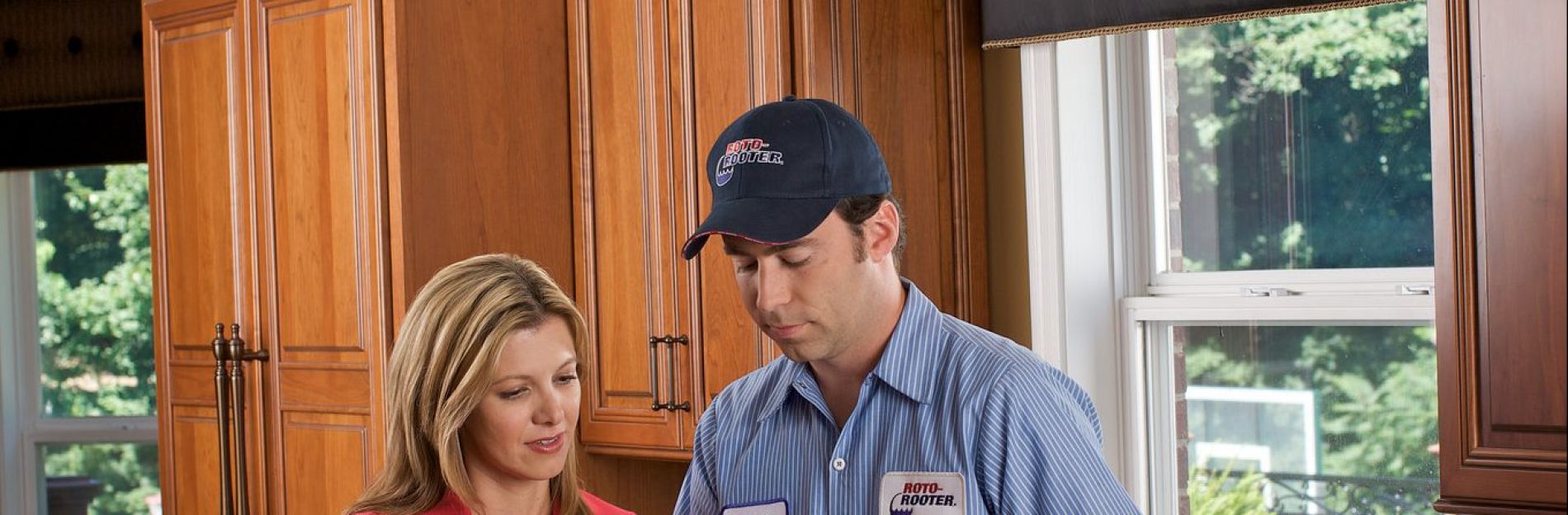 Paul from RotoRooter showing a client a work order on a tablet computer