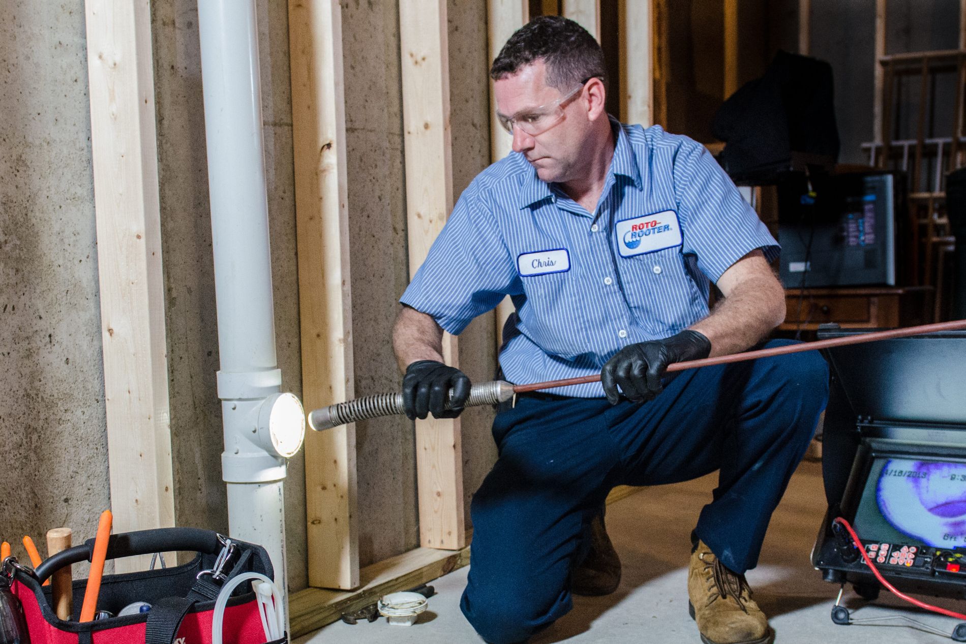 Plumber with Roto Rooter using a Roto Rooter to clean a home's piping