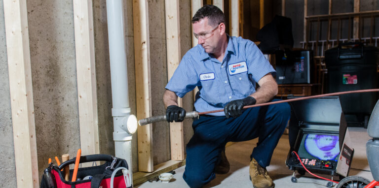 Plumber with Roto Rooter using a Roto Rooter to clean a home's piping